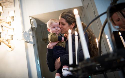 Mamma och barn vid ljusbärare