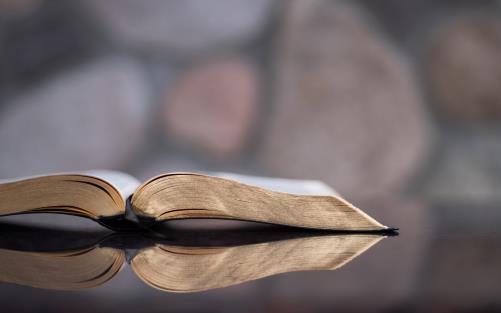 Uppslagen bibel liggande på en spegel