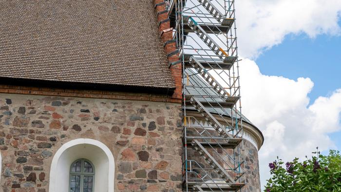 Byggnadsställning uppställd för renovering längs korsidan av Gamla Uppsala kyrka