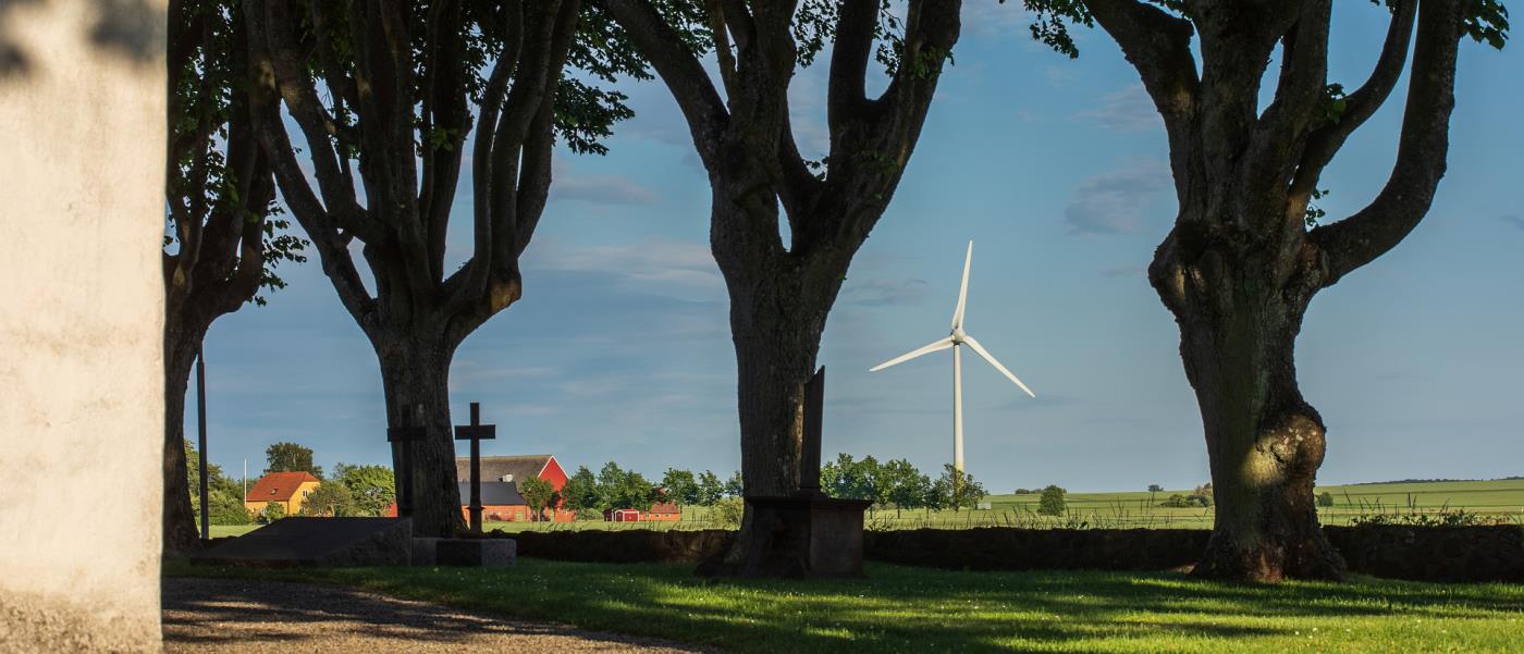 Vindkraftverk i närheten av kyrka.