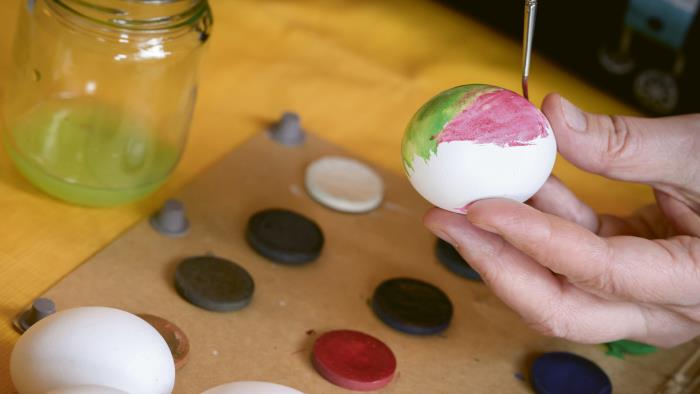 Person målar ägg under påskhögtiden. 
