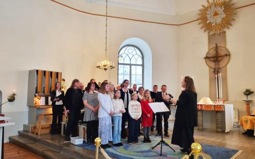 Människor står i koret av kyrkan och sjunger