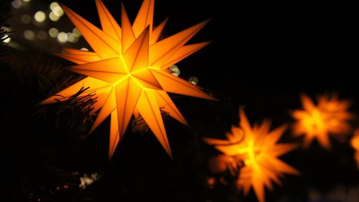 Lysande julstjärnor mot en svart bakgrund.