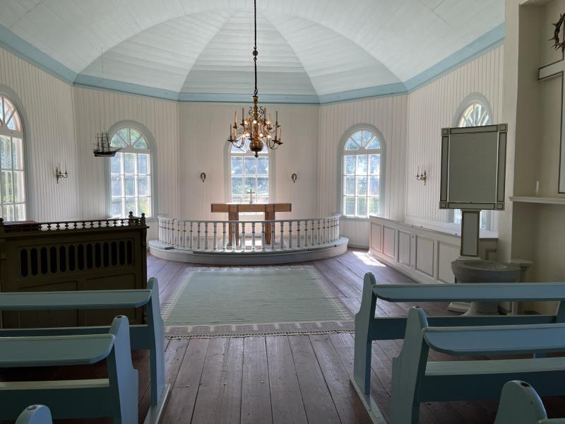 Altargång och altare, vita träväggar i Fågelö kapell.