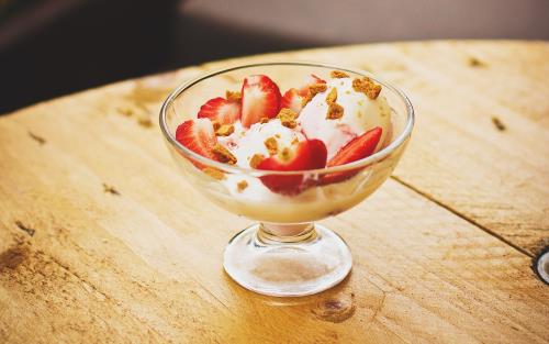 Jordgubbar och vaniljglass i en glas skål på for.