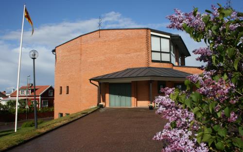 Kyrka med syrénblom i förgrunden