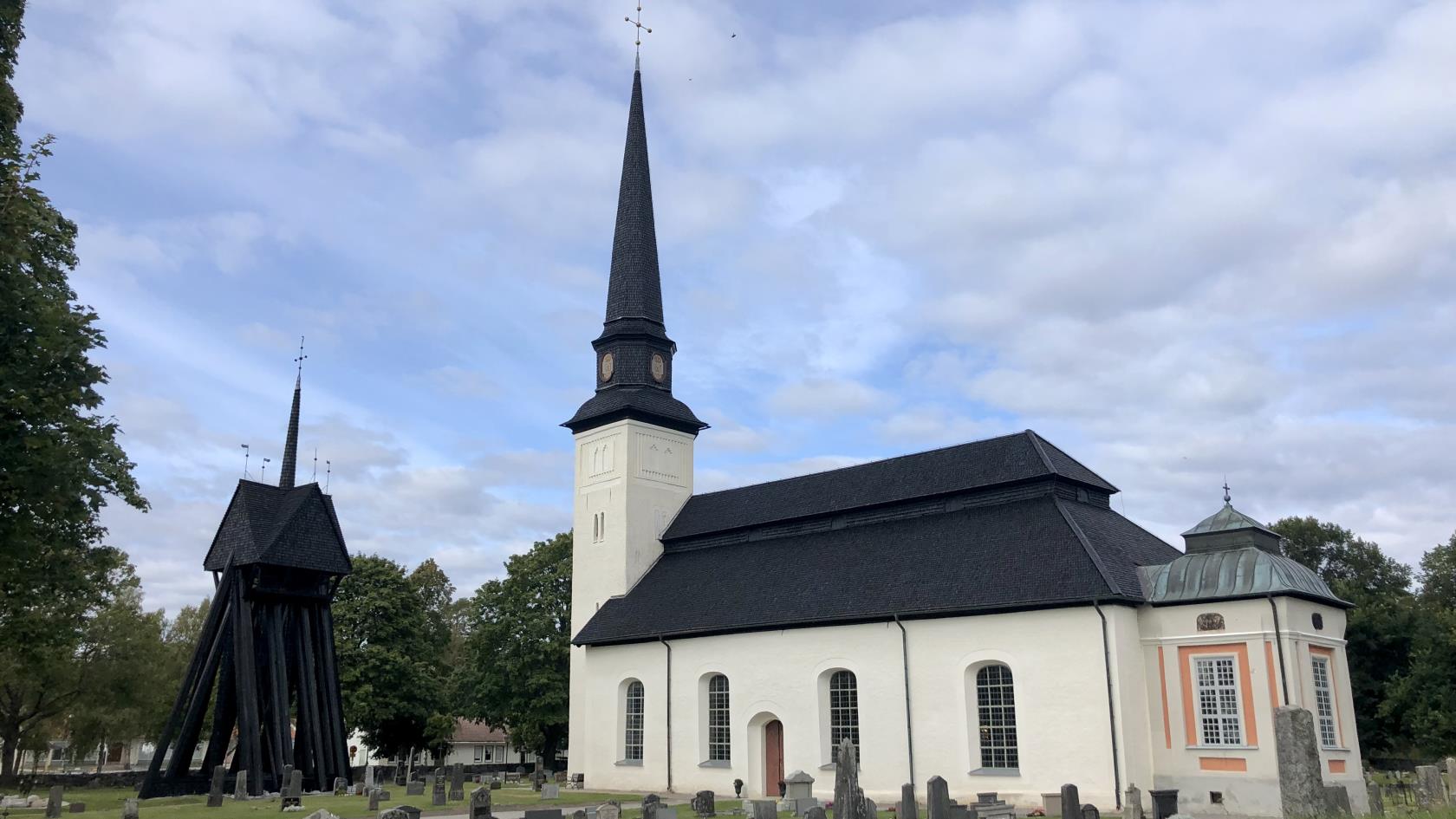 Glanshammars kyrka. Vit kyrka med svart träspånstak med gröna omgivningar