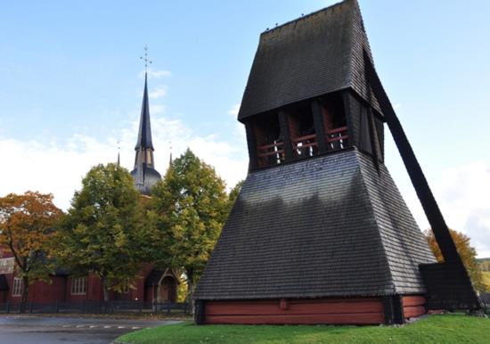 Klockstapeln med Ljusnarsbergs kyrka i bakgrunden
