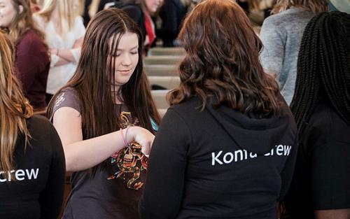 Unga tjejer i kyrkan i bakgrunden och konfacrew i svarta tröjor i förgrunden.