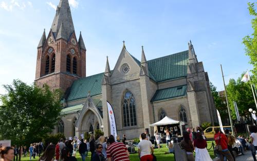 Bilden visar S:t Nicolai kyrka och rörelse på stan. Konfirmander är på festen "Inte som du tror".