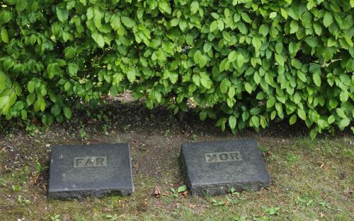 Två gravstenar med orden "far" och "mor"
