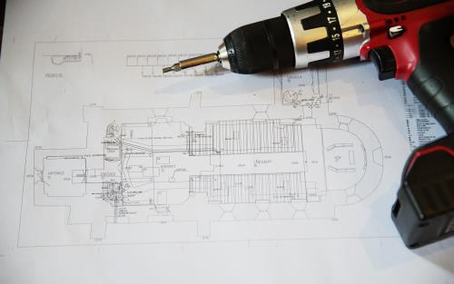 En skruvdragare som ligger på en ritning av en kyrka.