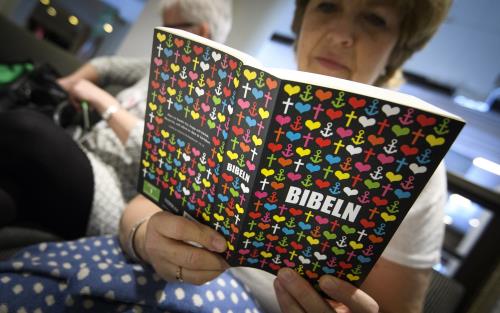 En äldre kvinna läser en bibel.