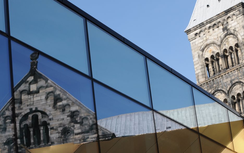 Lunds domkyrka speglas i en byggnads glasfasad.