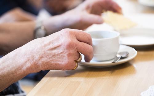 Någon lyfter upp en kaffekopp.