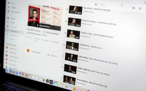 En laptopp har en Youtube-spellista med olika intervjuer uppe på skärmen.