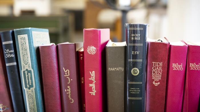 Biblar på olika språk står i en bokhylla i kyrkan.