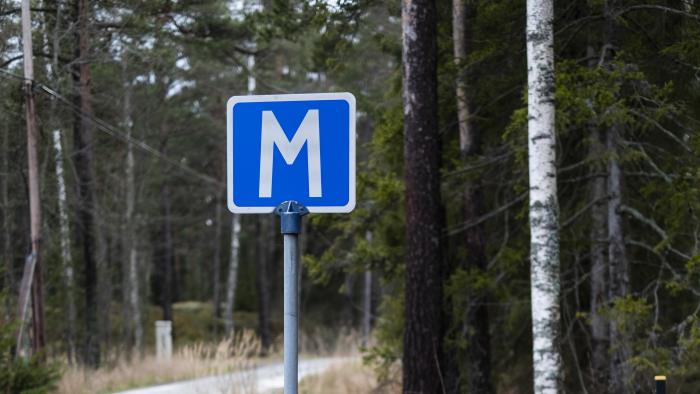 En skylt för mötesplats på en väg i skogen.