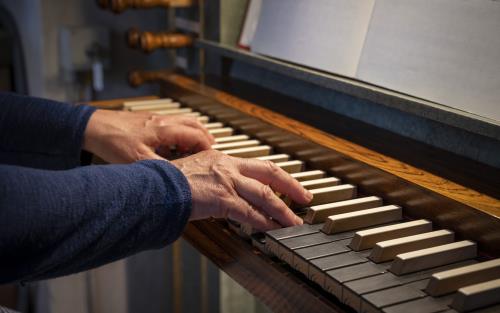 Ett par händer spelar på en kyrkorgel.