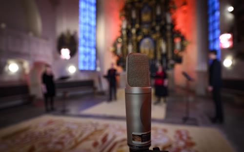 En mikrofon står uppställd för en konsert i kyrkan.