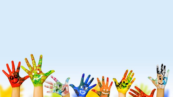 Några barnhänder målade i olika färger sträcker sig mot himlen.