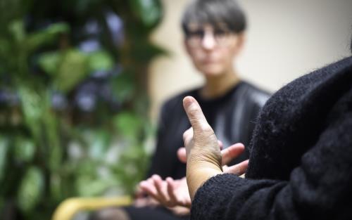 Två svartklädda personer sitter och samtalar.