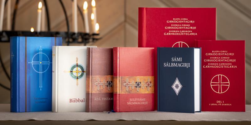 Olika kyrkböcker på samiska står uppställda på ett bord.