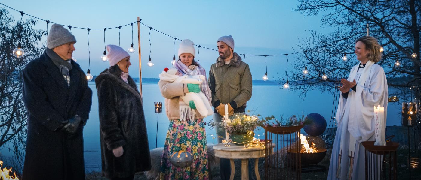 Ett litet utomhusdop i vintertid vid ett öppet vatten.