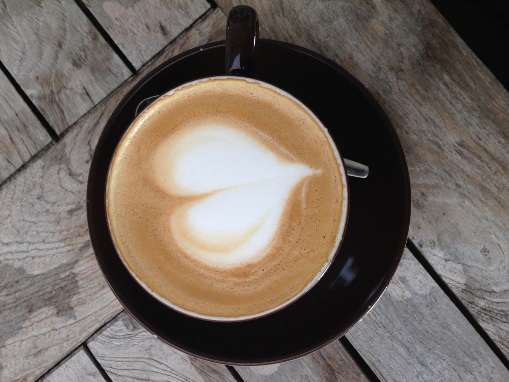 Bilden föreställer en kaffekopp med ett hjärta i mjölken