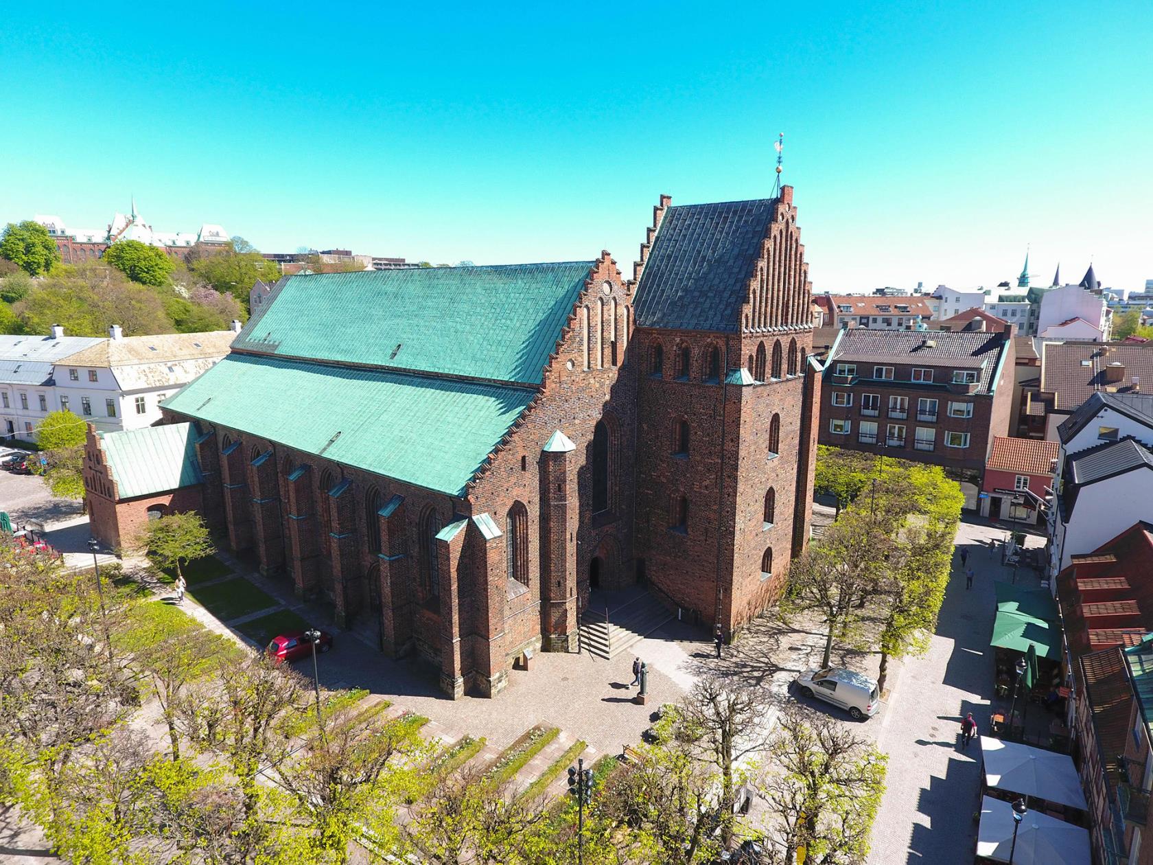 S:ta Maria kyrka i Helsingborg ses snett uppifrån. Det är en röd, medeltida tegelkyrka med koppartak.