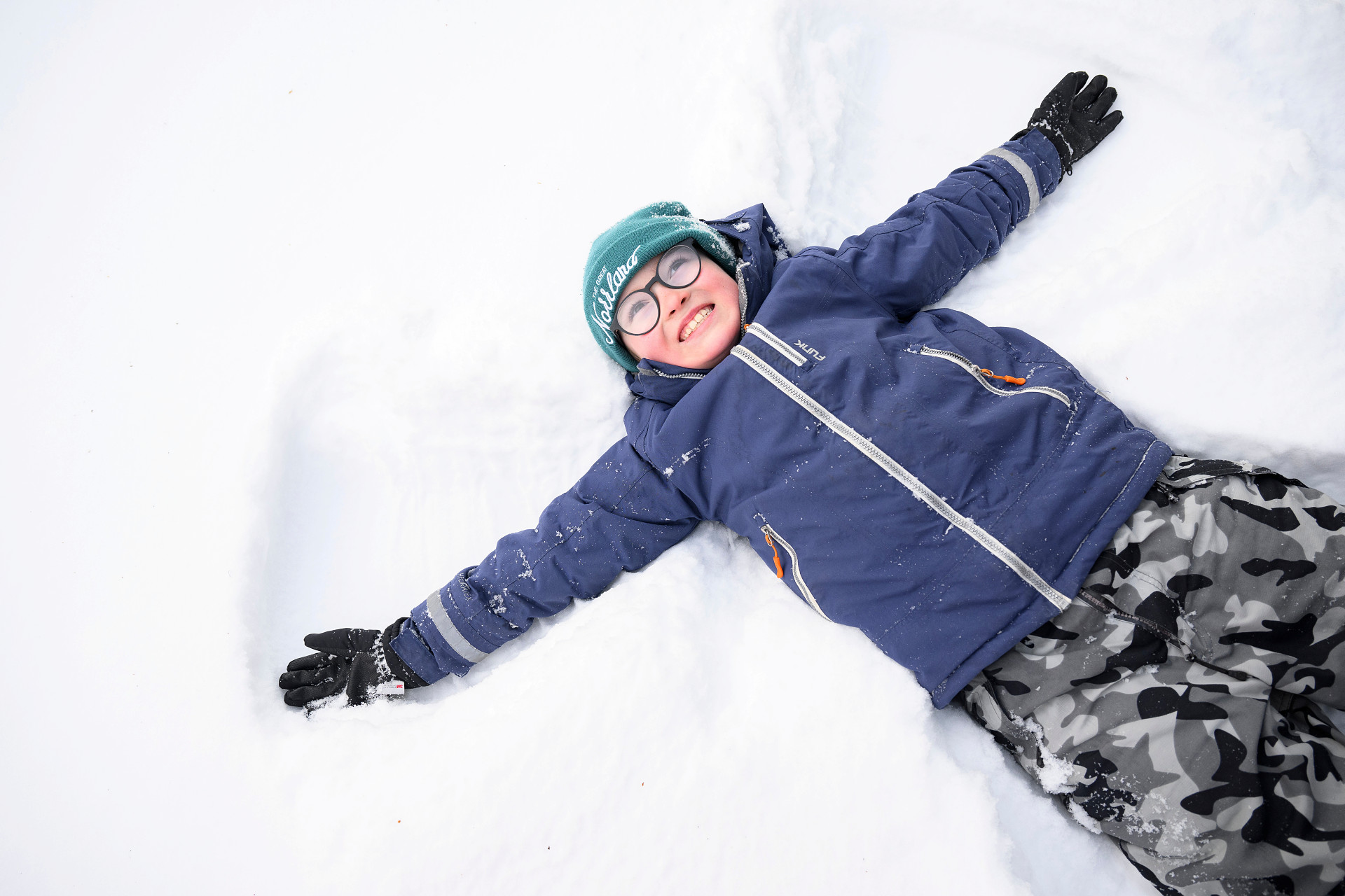 Ett barn gör en snöängel.
