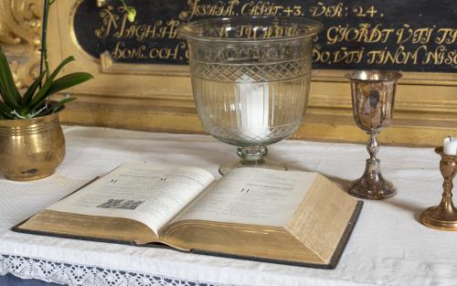 En bibel ligger uppslagen på ett bladguldsmyckat altare.