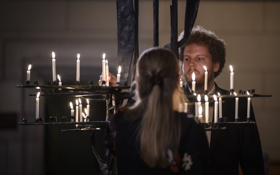 Två personer tänder ljus i Uppsala domkyrka.