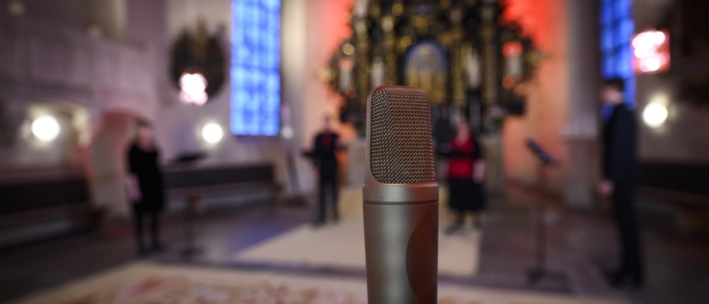 En mikrofon står uppställd för en konsert i kyrkan.