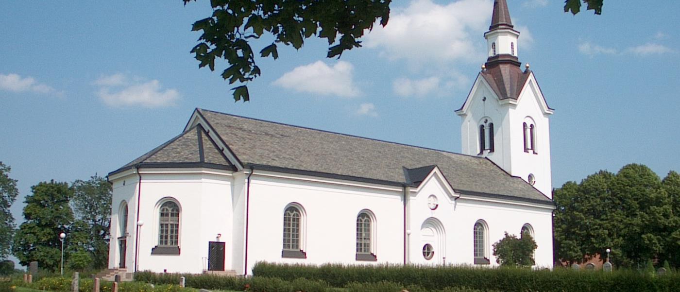 Högby kyrka med gravstenar i förgrunden.