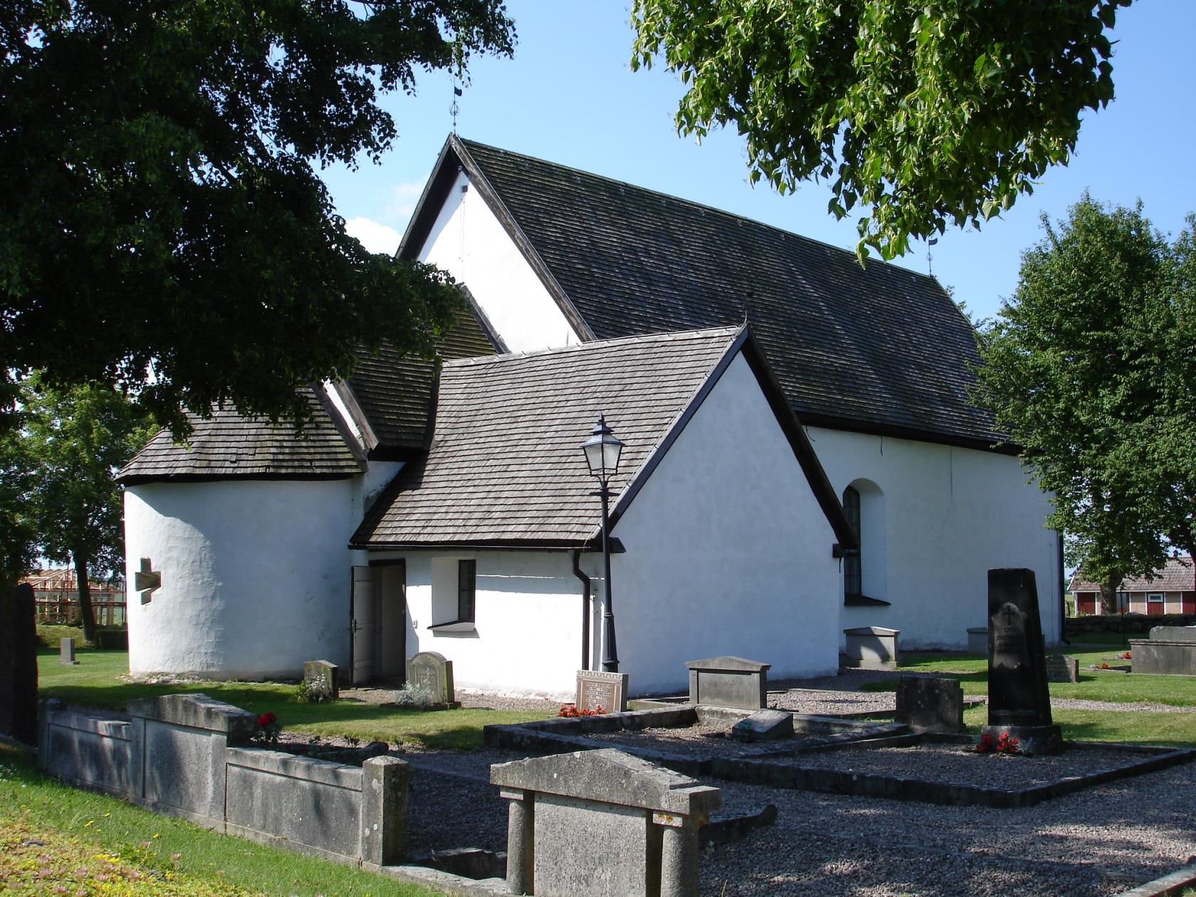 Kumla kyrka. En liten vitrappad stenkyrka med spåntak.