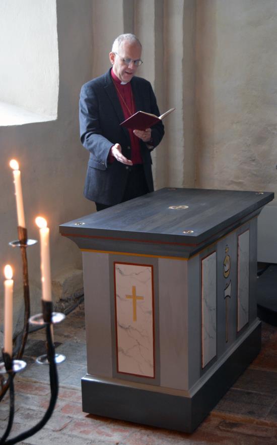 Biskop Martin Modéus inviger S:t Olofsaltaret i Örtomta. Kronan, inskriven i riksäpplet, är ett tecken på helgonets kungliga värdighet och under den finns ännu ett attribut, yxan.