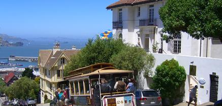 Spårvagn i San Francisco. Svenska flaggan och havet syns i bakgrunden.