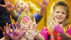Barn som målat sina händer och sträcker fram dessa.