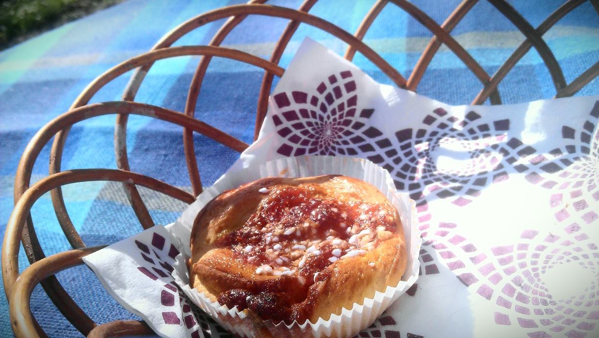 Syntolkning: en ensam bulle i en flätad brödkorg som står på ett bord med blårutig duk.