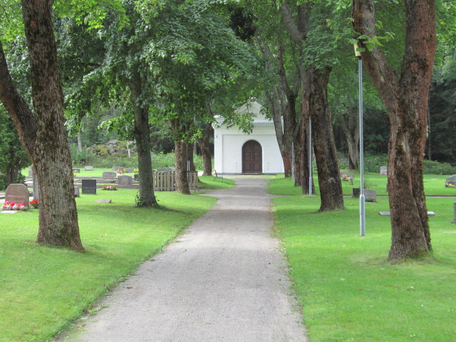 Vy mot gamla gravkapellet sett från parkeringen. Till vänster kvarter A och till höger kvarter B. Ljusne kyrkogård