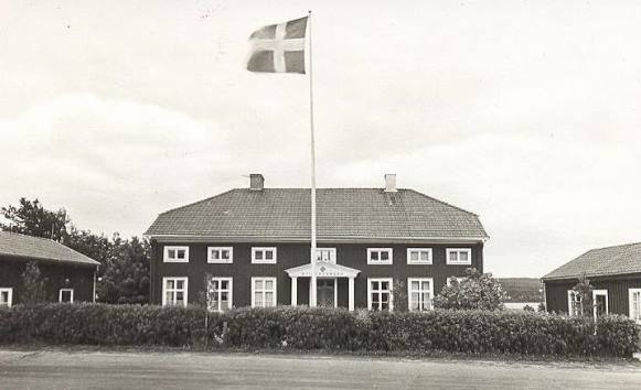Svartvitt foto på framsidan av stiftsgården i Undersvik med hissad flagga