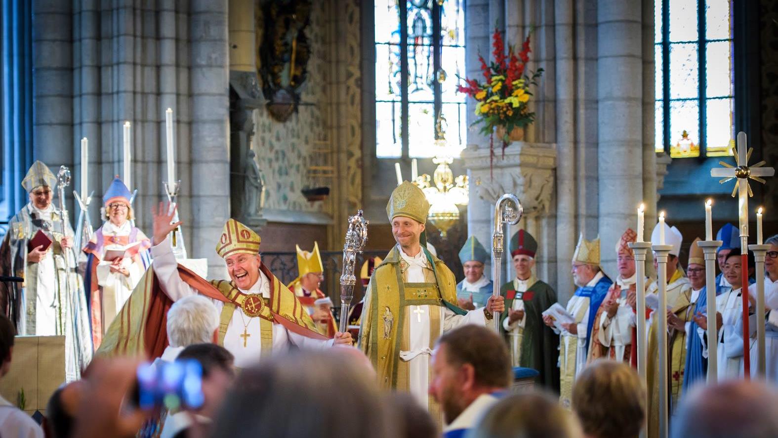 En glad biskop Johan Dalman vinkar till de många besökarna i Uppsala domkyrka. 