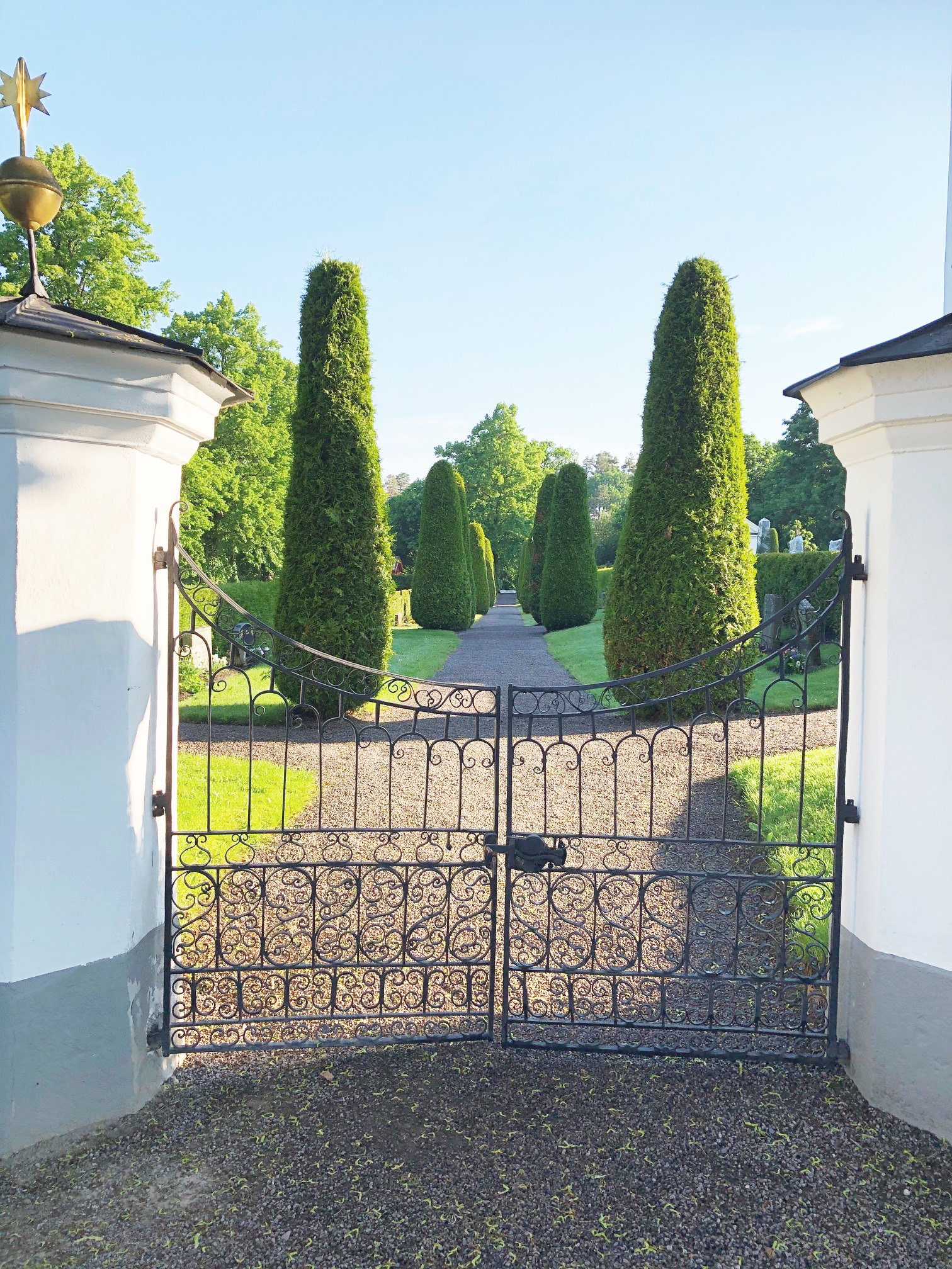 grindarna in till Vårdnäs kyrkogård, gröna träd i bakgrunden