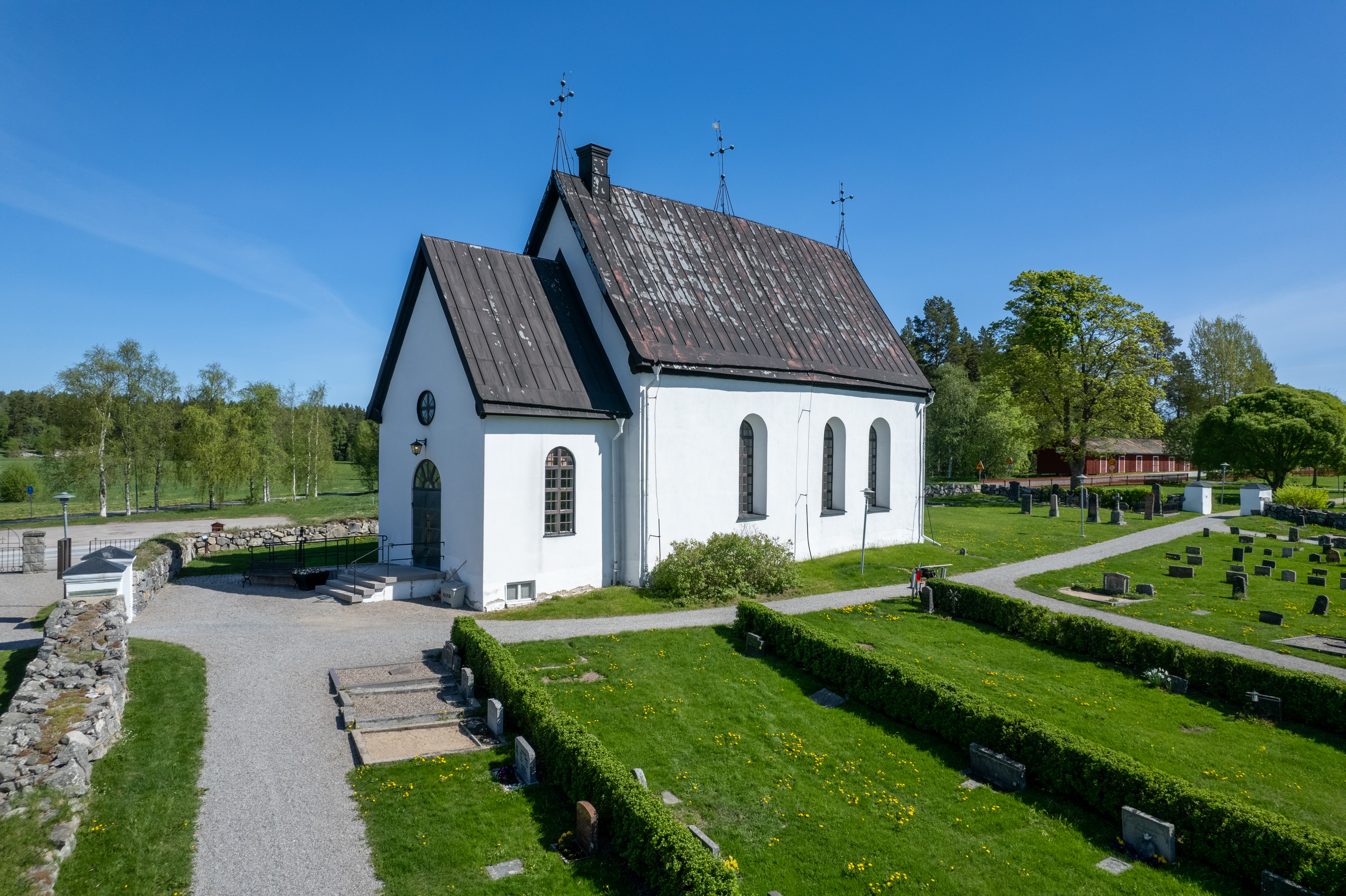 En drönarbild på S:ta Maria kyrka omgiven av kyrkogården