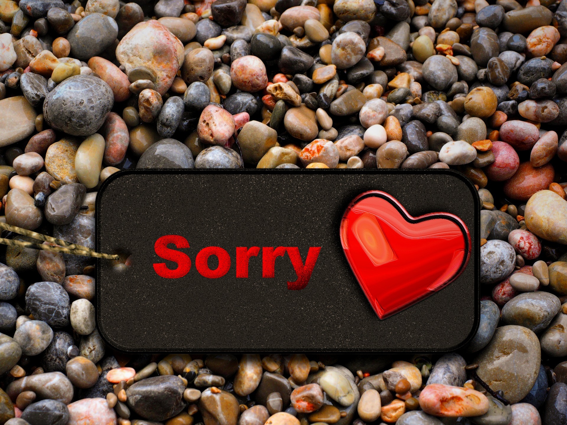 En skylt på en strand med ett hjärta och texten "Sorry" / "Vi är ledsna"