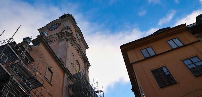 Det är mörkt och snöigt då den nya takstolen och kopparplåten lyfts till taket med skylift. Inne på gården stryks sandstensputs på väggen och runt om Storkyrkan reses byggnadsställningar upp. Efter några timmar klarnar det upp. Det är full fart!