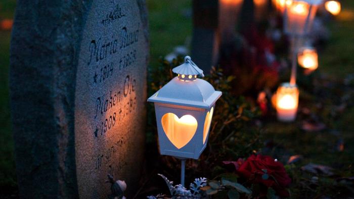 Ljus som lyser vid gravarna på kyrkogården.