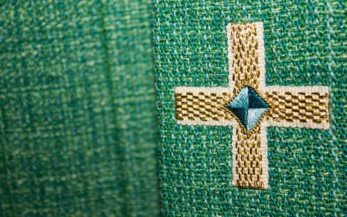 Närbild av kors på grönt tyg.