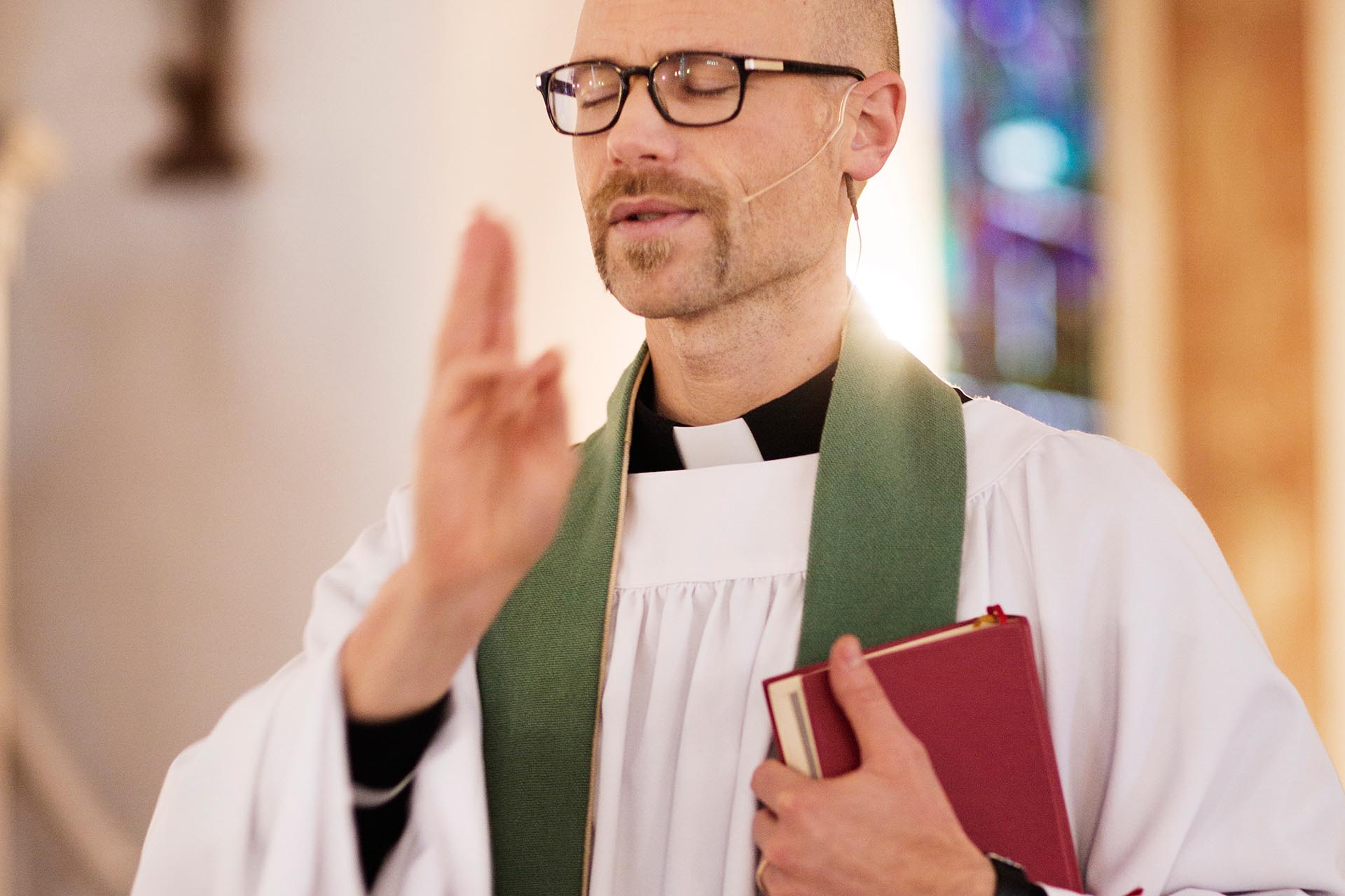 Präst utdelar välsignelsen.